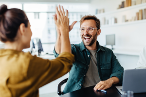 Dwie osoby przybijają piątkę z okazji udanego projektu.